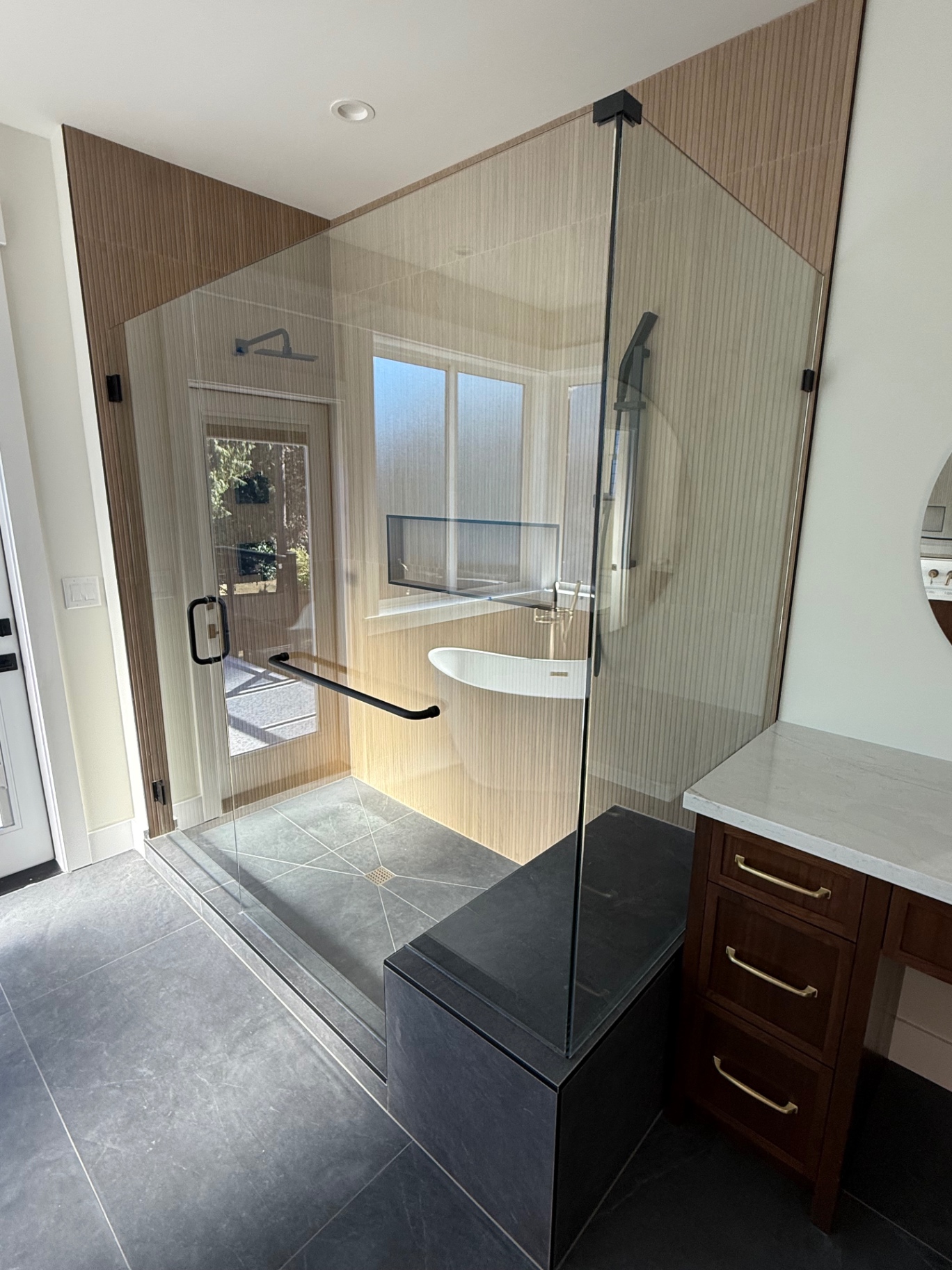 Curbless tile shower with black hardware and freestanding tub